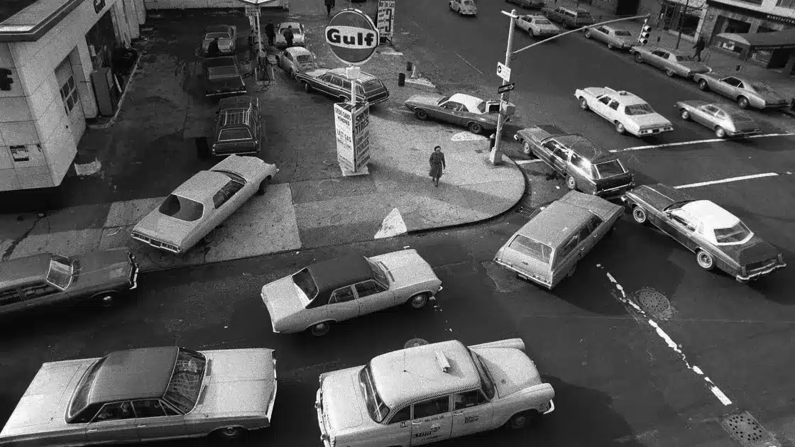 Vintage scene of a 1970s gas station during the oil crisis, emphasizing the need for renewable energy.