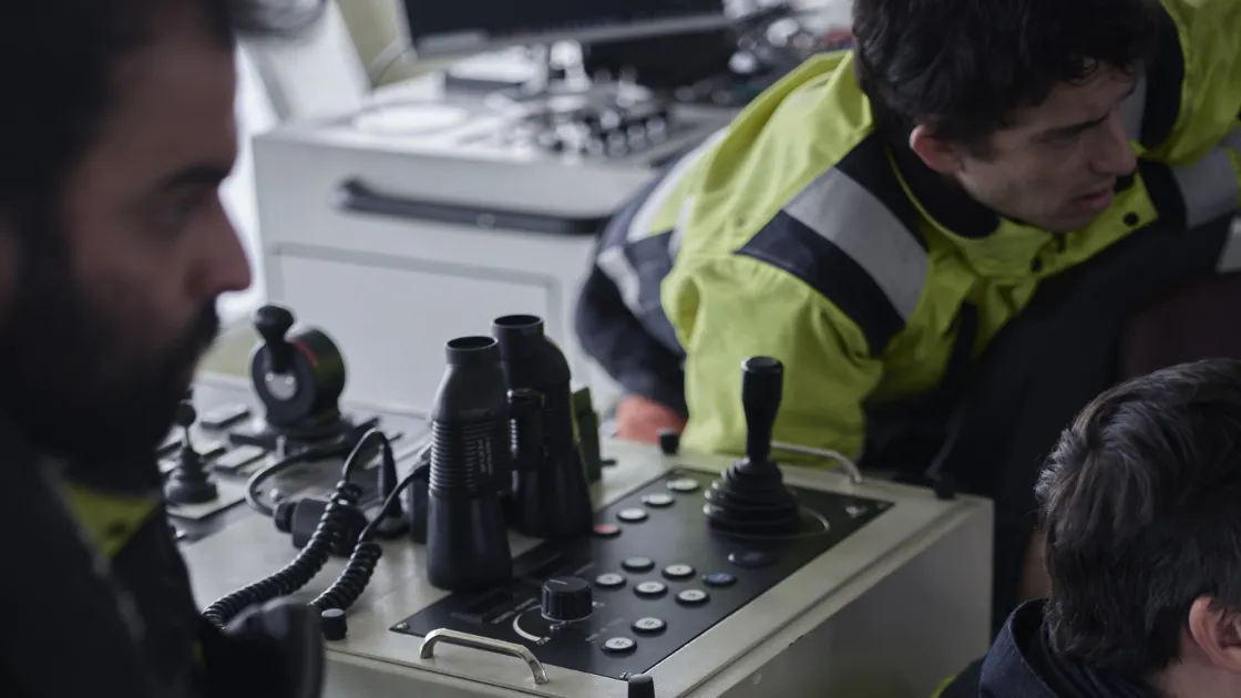 Crew members of CorPower Ocean operating navigational equipment on a vessel.