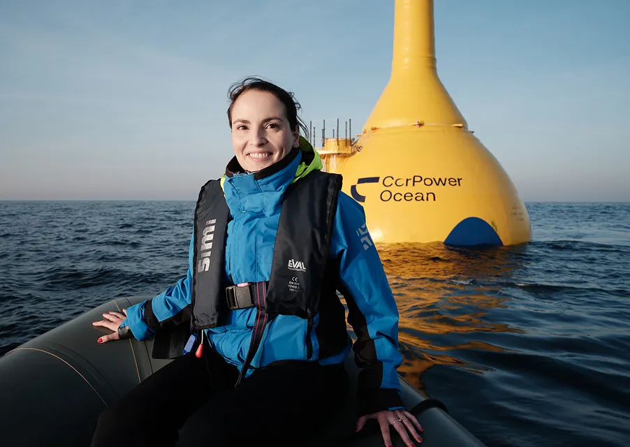 CorPower Ocean engineer in safety gear beside yellow C4 wave energy converter at sea