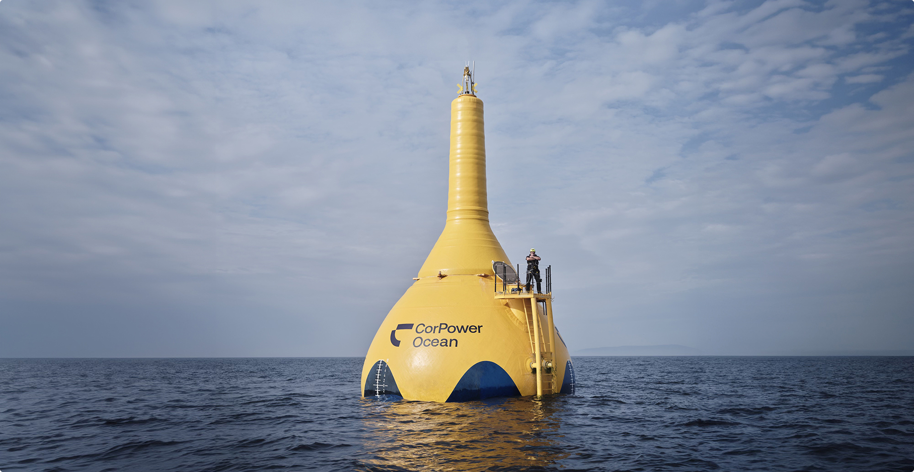 CorPower Ocean wave energy buoy floating at sea, yellow spherical device with tower structure generating renewable electricity from ocean waves.