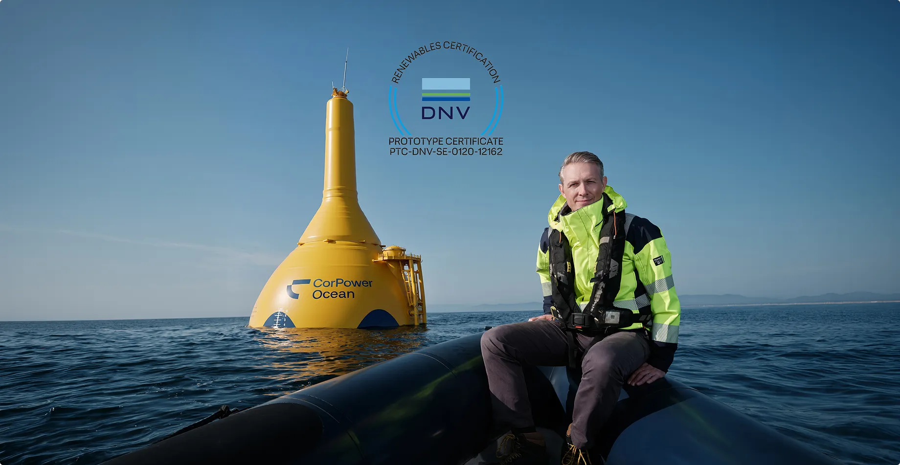 CorPower Ocean CEO Patrik Möller beside the yellow C4 wave energy converter with the DNV Prototype Certificate mark